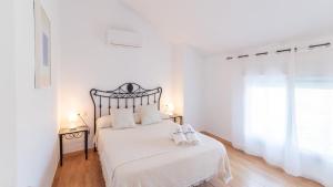 une chambre blanche avec un lit avec deux serviettes dessus dans l'établissement Casa La Primorosa El Gastor by Ruralidays, à El Gastor 29 autres photos