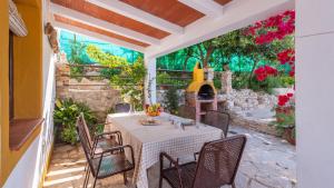 un patio avec une table, des chaises et une cheminée dans l'établissement Casa La Primorosa El Gastor by Ruralidays, à El Gastor