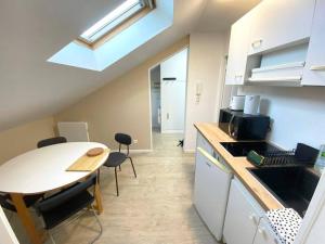 a kitchen with a table and a table and chairs at Le nid citadin - avec place de parking in Tours