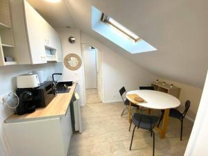 a kitchen with a table and a small table and chairs at Le nid citadin - avec place de parking in Tours