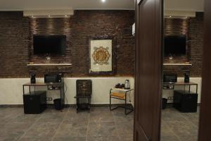 una stanza con due televisori su un muro di mattoni di Home di Giordy a Catania Altre 31 foto