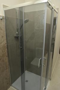 una doccia con una porta in vetro in un bagno di Home di Giordy a Catania