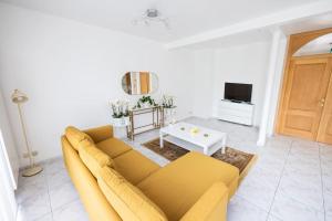 a living room with a yellow couch and a table at Résidence Orchidée in Zaventem