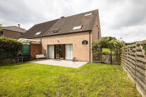 a brick house with a fence in a yard at Résidence Orchidée in Zaventem