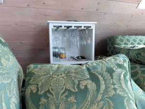 a room with two chairs and a cabinet with glass bottles at Haus "Guck - ins - Tal" in Sasbachwalden