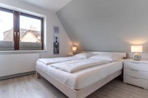 une chambre blanche avec un grand lit et une fenêtre dans l'établissement Summer Diek Summerdiek 6, à Sankt Peter-Ording