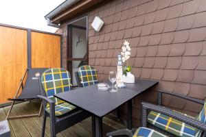 une table noire et des chaises sur une terrasse dans l'établissement Summer Diek Summerdiek 6, à Sankt Peter-Ording