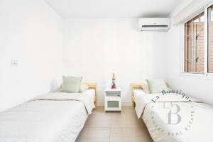 two beds in a white room with a window at Oasis con piscinas y jardines en Maspalomas in Maspalomas +28 photos