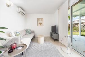 a living room with a couch and a tv at Oasis con piscinas y jardines en Maspalomas in Maspalomas