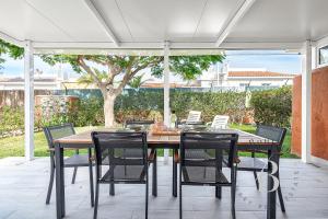 a wooden table and chairs on a patio at Oasis con piscinas y jardines en Maspalomas in Maspalomas
