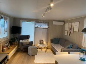 un salon avec un canapé et une table dans l'établissement Bujając w obłokach domek nr 22, à Gąski 6 autres photos