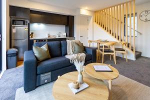 クライストチャーチにある2 Bed, 2 Bath w Sofa Bed - Great Cafes Nearbyの青いソファとテーブルのあるリビングルーム