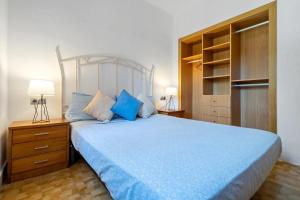 a bedroom with a bed with a blue comforter at Casa a 50 metros de la playa in Comarruga