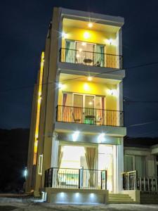 a large yellow building with a balcony at night at Tiffany Homestay in Eluan