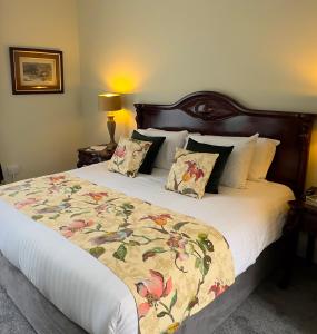 una camera da letto con un grande letto con un copriletto floreale di Ennismore House a Cork