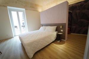 een slaapkamer met een groot wit bed en een raam bij La chicca in Matera