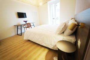 een slaapkamer met een bed, een bureau en een televisie bij La chicca in Matera
