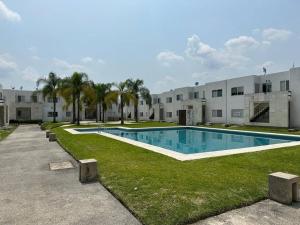 a swimming pool in front of a building at Departamento en Fraccionamiento in Oacalco