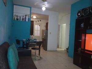 a living room with a table and a blue wall at Departamento en Fraccionamiento in Oacalco