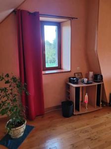 una stanza con una pianta in vaso e una finestra di Au coeur de notre ferme céréalière a Romilly-sur-Aigre