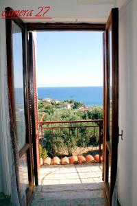 an open door to a balcony with a view of the ocean at Cardiff Hotel in Marina di Camerota