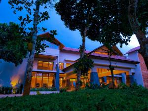 an exterior view of a house with trees at Sterling Lontano Waterfront Wayanad in Meppādi