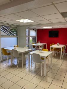 a dining room with tables and chairs and a tv at Premi&egrave;re Classe Montlu&ccedil;on Saint Victor in Saint-Victor