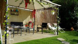 a gazebo with chairs and a table in a yard at Mansarda con vista lago in Sulzano