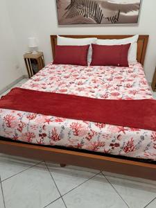 a bed with a red comforter on top of it at Lady's house in Grammichele