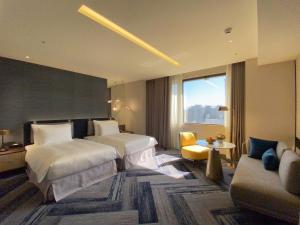 a hotel room with two beds and a couch at Monarch Plaza Hotel in Taoyuan
