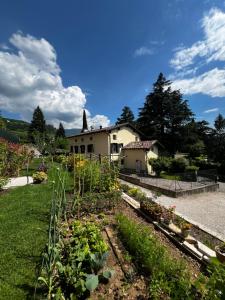 a garden with a house in the background at B&B Ca'rina in Rovereto