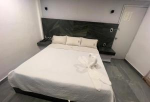 a white bed with a angel sitting on top of it at Hotel Aquario in Mexico City