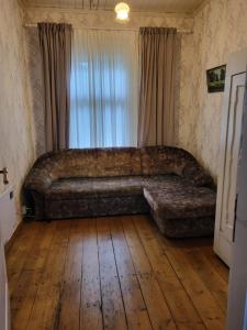 a large couch in a room with a wooden floor at Summer cottage in Jurmala in Jūrmala