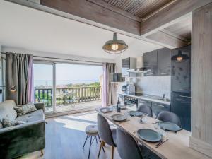 een keuken en woonkamer met een tafel en stoelen bij Apartment Les Eaux Vives 1 & 2-2 by Interhome in Saint Pierre La Mer