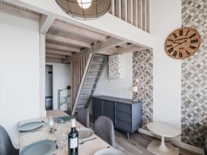 een eetkamer met een trap en een klok bij Apartment Les Eaux Vives 1 & 2-2 by Interhome in Saint Pierre La Mer