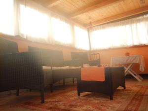 ノートにあるCasa Vacanze - Attico Dorisのテーブルと椅子、窓が備わる客室です。
