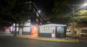 a small building on the side of a street at night at Hotel Aquario in Mexico City