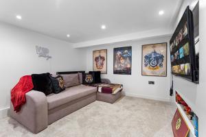 a living room with a couch and posters on the wall at The Hogwarts Retreat - Cinema Room - in Watford