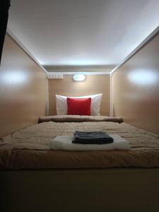 sypialnia z łóżkiem z czerwoną poduszką w obiekcie High5 Guesthouse w mieście Pattaya Central