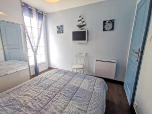 a bedroom with a bed and a tv on a wall at Holiday Home St Pierre by Interhome in Saint Malo