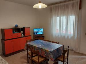 a dining room with a table and a television at Flavia Flats in Bibione
