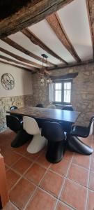 a dining room with a table and leather chairs at El Balcón de Valles in Reocín