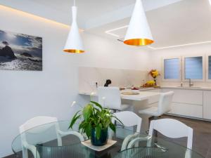 a kitchen and dining room with a glass table and white chairs at Holiday Home Berganti by Interhome in Tossa de Mar