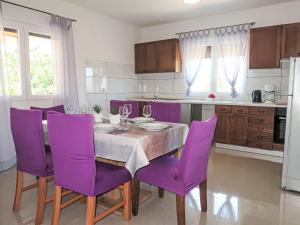 a kitchen with purple chairs and a table with wine glasses at Holiday Home Laura by Interhome in Potpićan