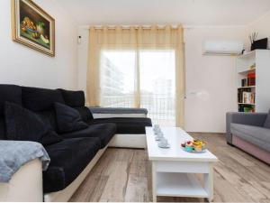 a living room with a black couch and a table at Apartment Apartamento la Moselle by Interhome in Miami Platja +16 photos