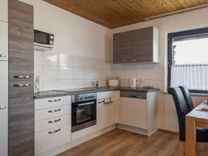 a kitchen with white appliances and a table and a window at Apartment Eifelnatur - Haus 2-1 by Interhome in Immerath
