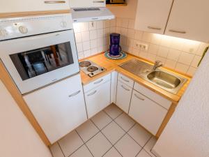 Apartment F 32 by Interhome في Dittishausen: مطبخ صغير مع دواليب بيضاء ومغسلة