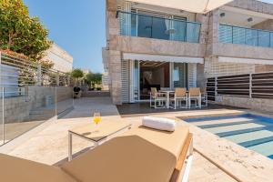a villa with a swimming pool and a house at Villa Olea ZadarVillas in Petrcane