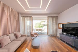 a living room with a couch and a television at Villa Olea ZadarVillas in Petrcane
