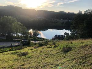 a view of a lake with a house on a hill at Stanica MODRAK - Najpiekniejszy ZAKĄTEK KASZUB in Ręboszewo